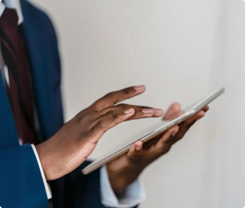 A person in a suit tapping on a tablet