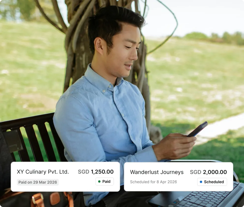 Two vendor payments, one already paid and one scheduled, over a photograph of someone checking their phone outdoors.