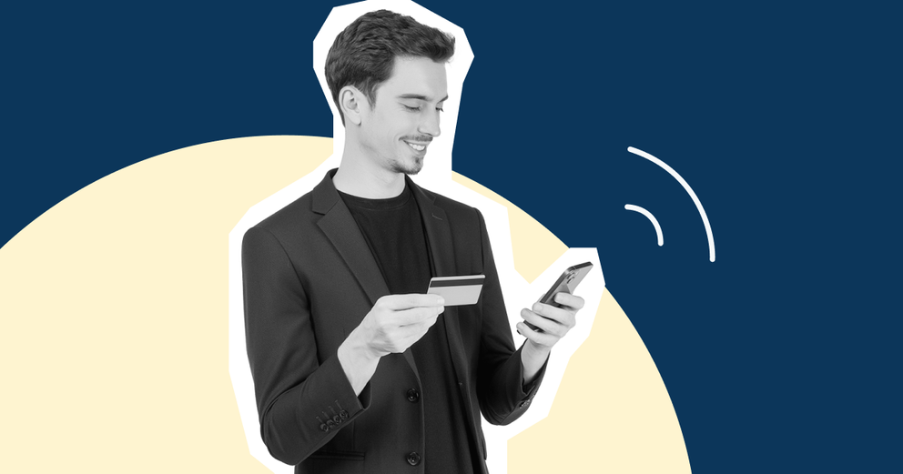 A man looking at a card and a phone.