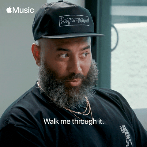 A bearded man in a cap looks over, captioned walk me through it