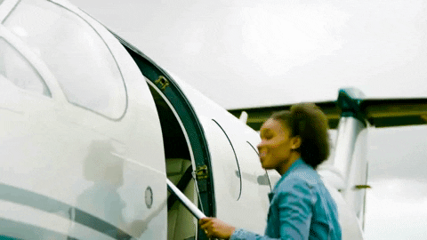 A traveller in a denim shirt boarding a small private jet with documents in hand