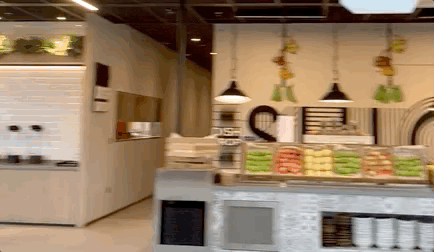 A bakery-style counter inside the office, trays of pastries and breads under pendant lights