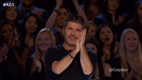 A man in an audience applauding enthusiastically