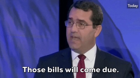 A man speaking on a TV panel, captioned those bills will come due