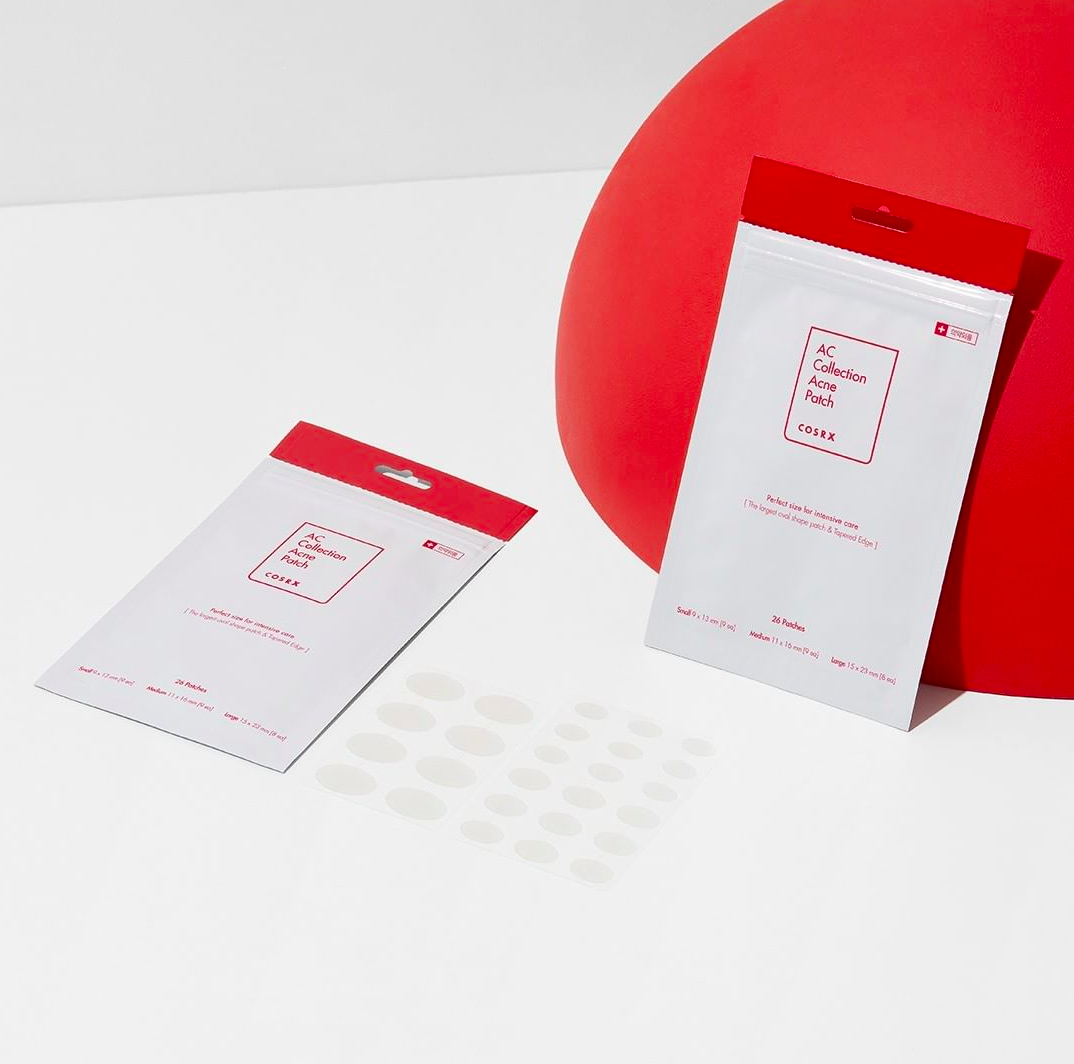 Two acne patch sachets with sheets of small round hydrocolloid patches beside them
